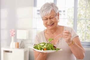 Older Woman Having a Salad and Smiling