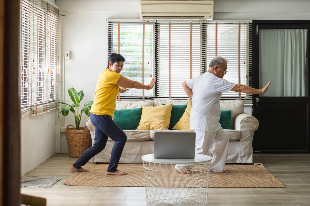 Older couple doing tai chi at home