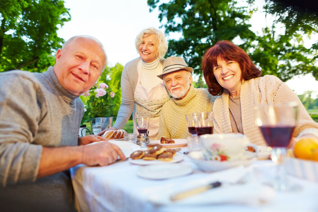 Group of older adults eating outdoors.